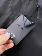 Black leather jacket fabric close-up with Prada tag and RFID label