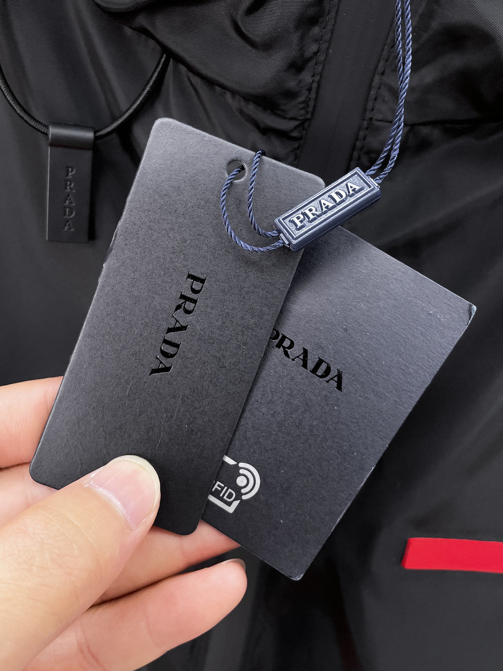 Long coat neck with PRADA hanging tag and drawstring loop