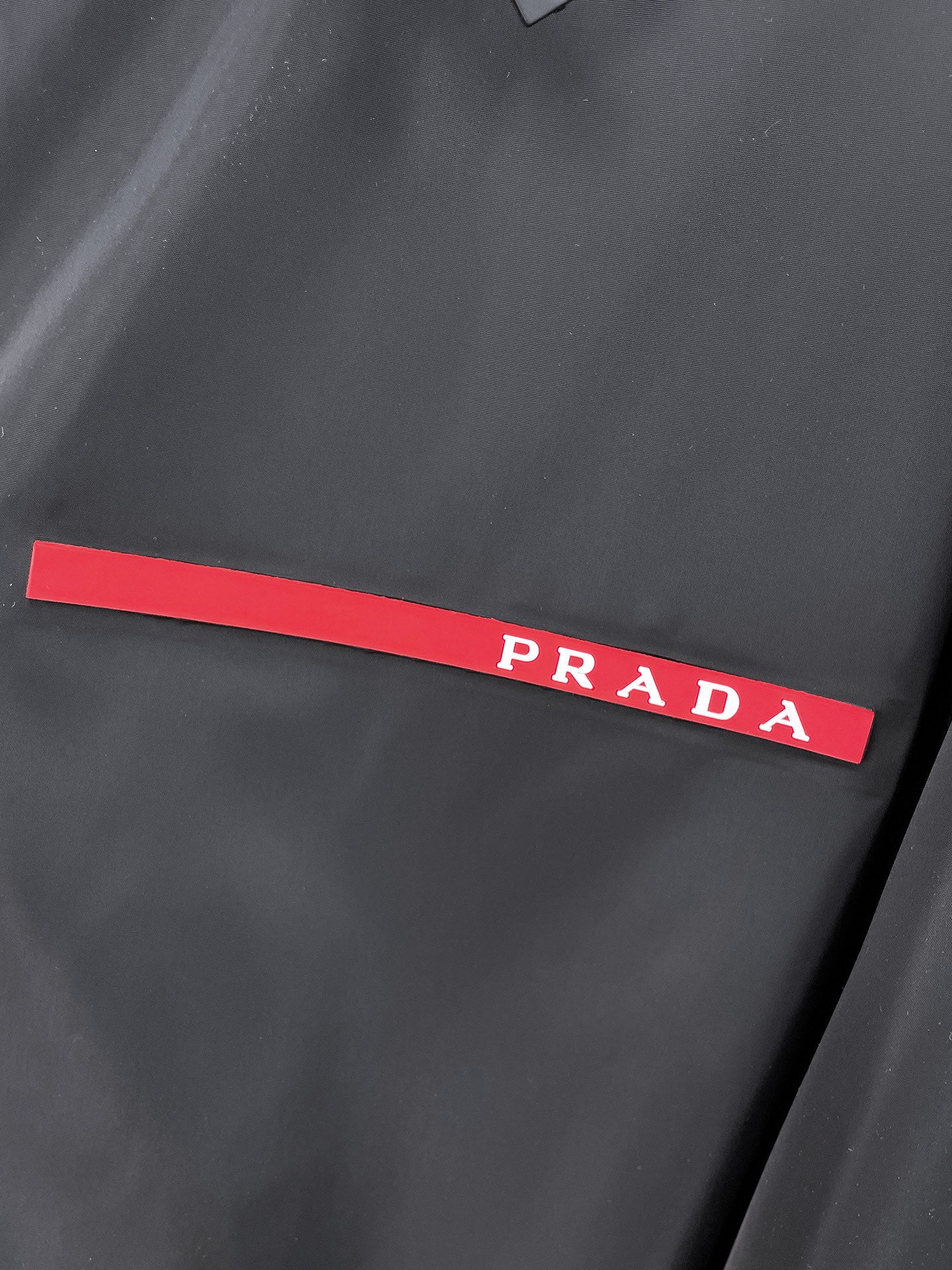 Prada red logo stripe on black long windbreaker jacket chest