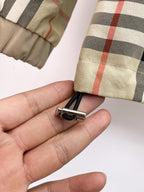 Zipper pull with small clip on plaid cuff fabric held in hand