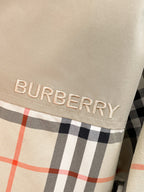 BURBERRY logo patch on beige fabric with black and red plaid trim