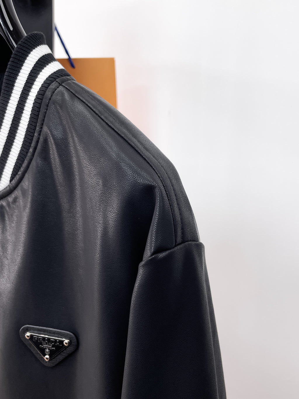 Prada black leather jacket with striped ribbed collar and metal logo plaque