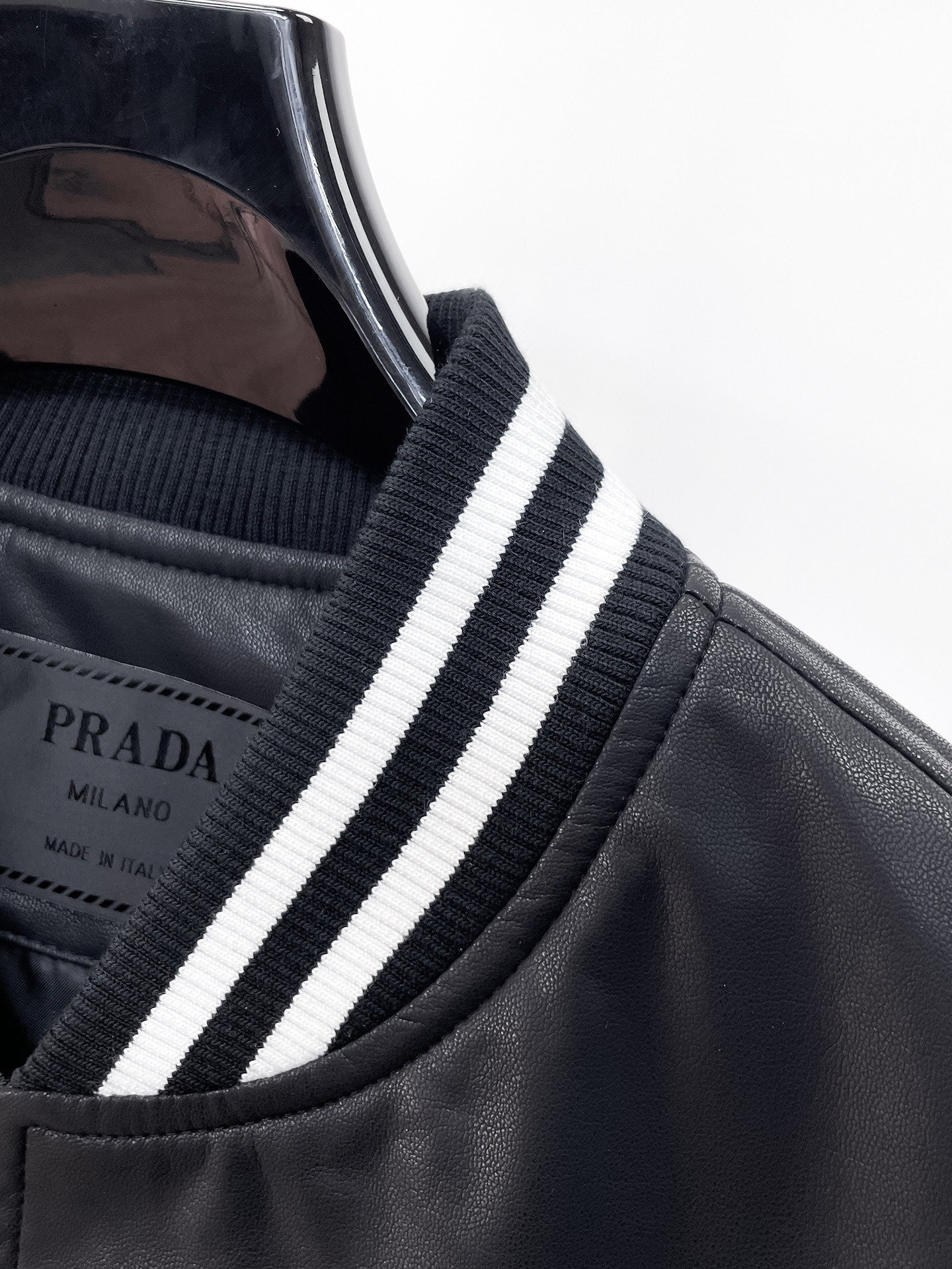 Black leather jacket collar with white and dark blue striped ribbed trim