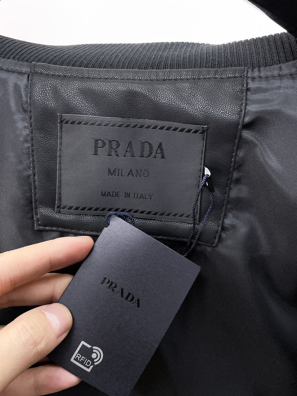 Prada Milano tag and RFID tag inside black leather jacket
