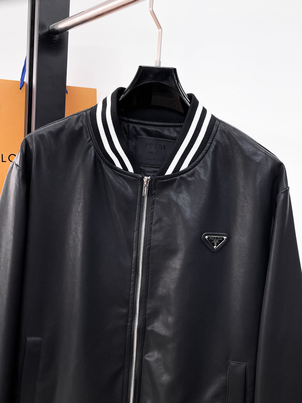 Black leather jacket with Prada triangle logo, striped collar trim, zip front