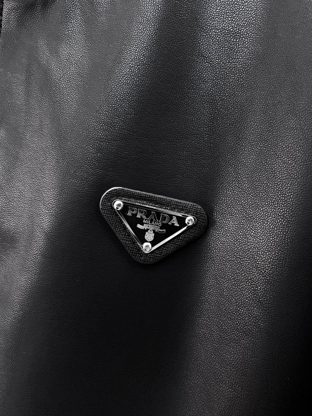 Black leather jacket with Prada triangle metal logo badge