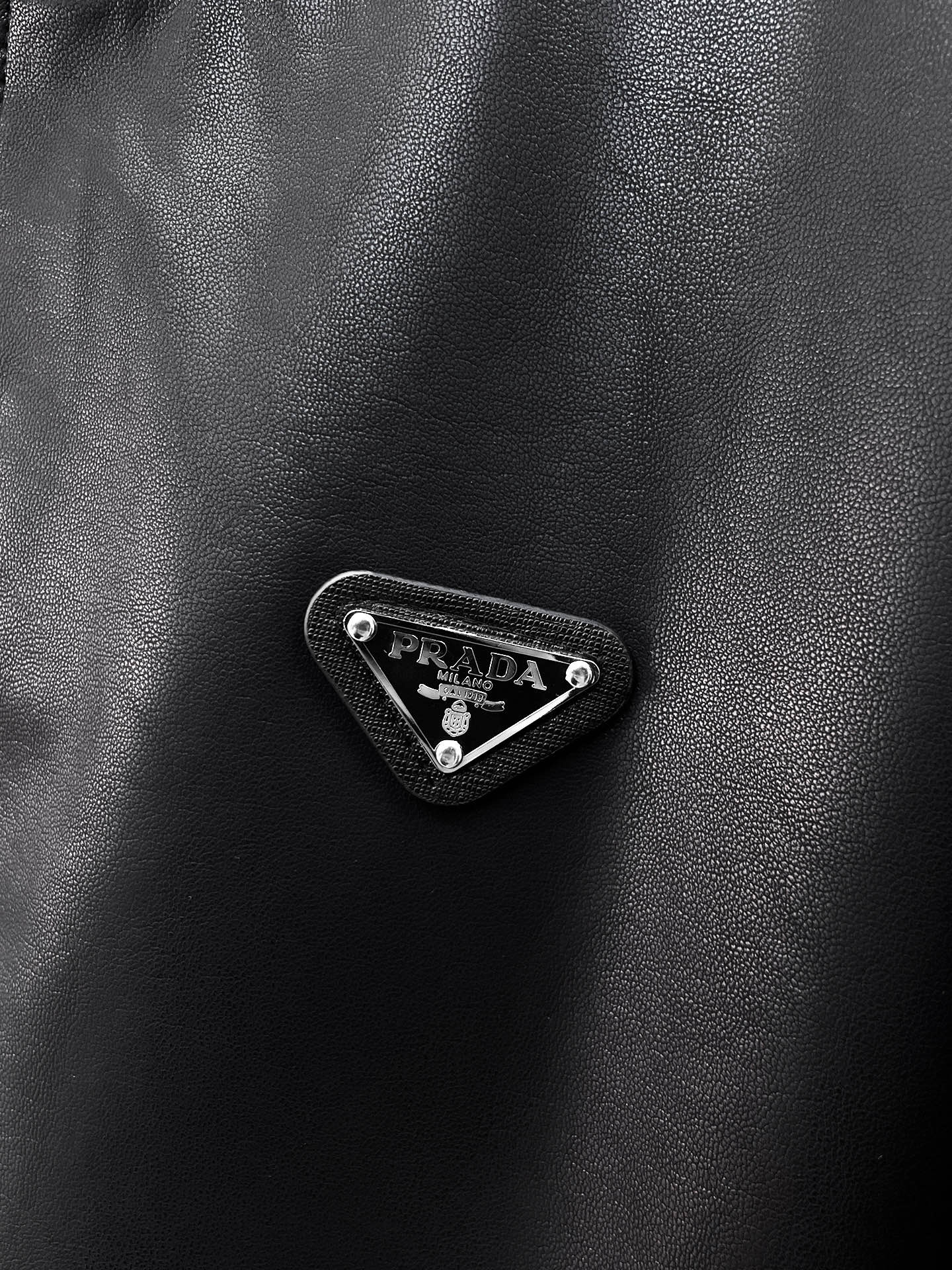 Black leather jacket with Prada triangle metal logo badge