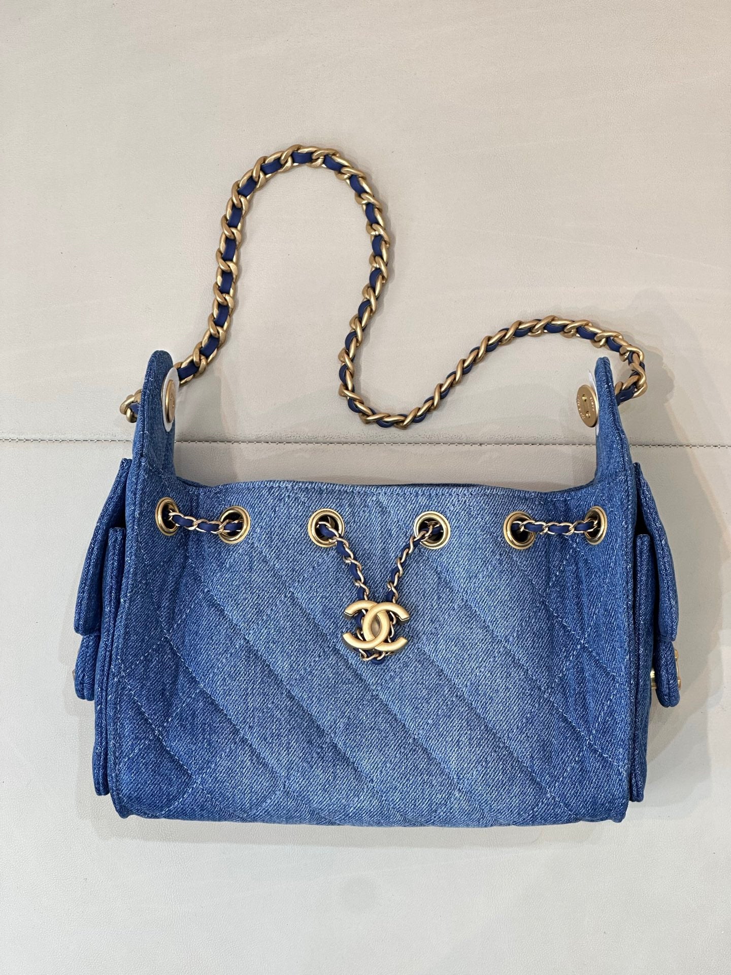 Chanel blue denim handbag with chain straps, gold CC logo and front dangle