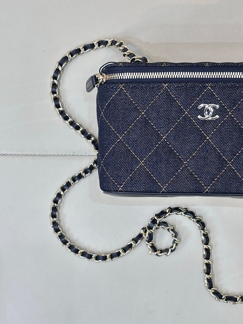 Chanel mini quilted bag in dark blue with top zip, CC emblem, and chain strap
