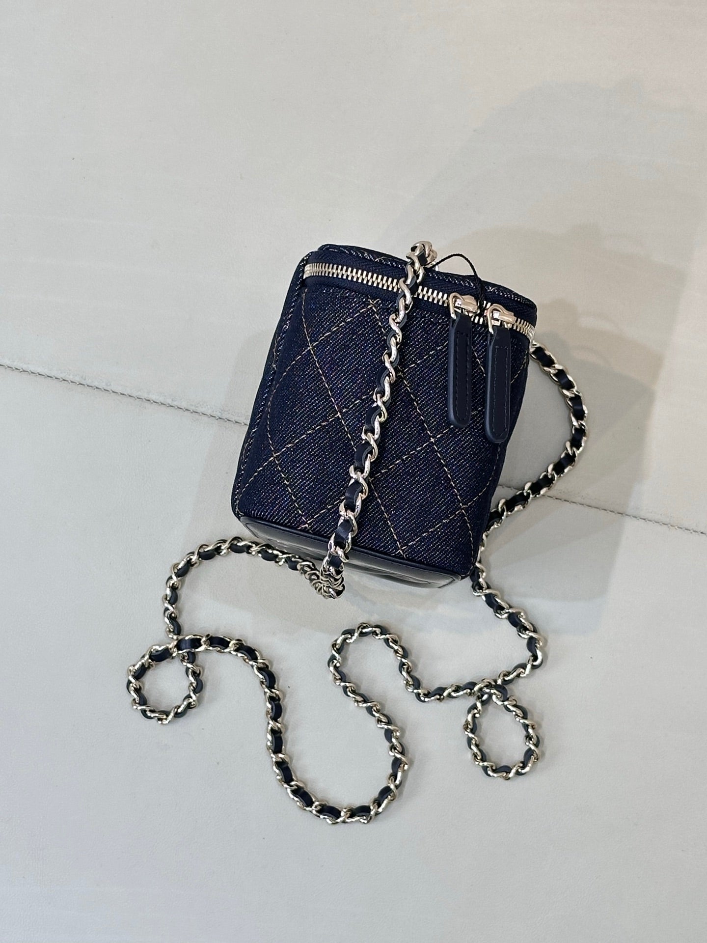 Chanel mini quilted bag in dark blue with chain strap and zipper, side view