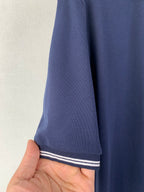 Navy polo shirt sleeve cuff with white and navy stripe trim