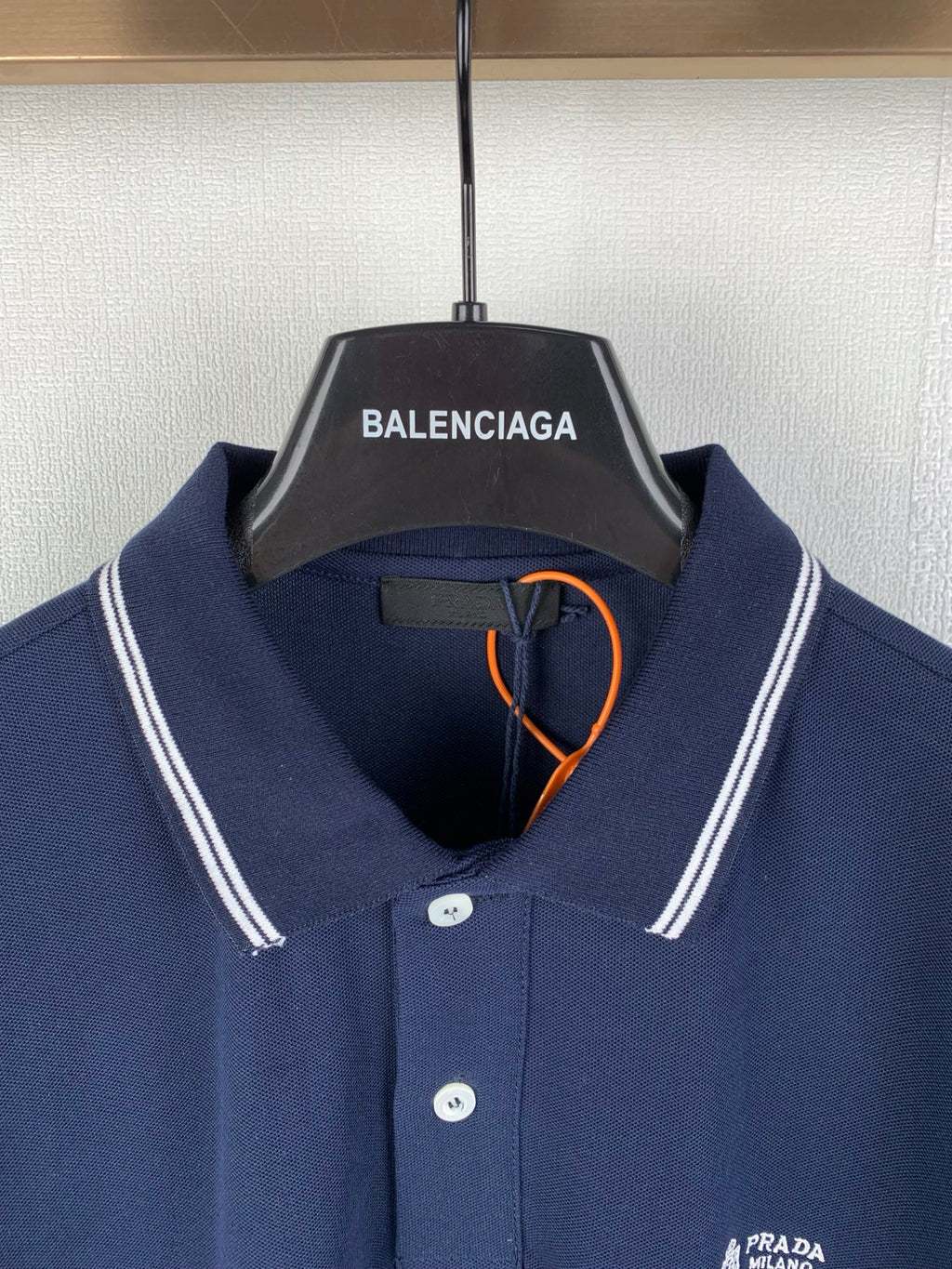 Navy polo shirt with button placket and Prada Milano logo at chest