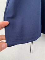 Navy polo shirt hem with small drawstring and knit texture