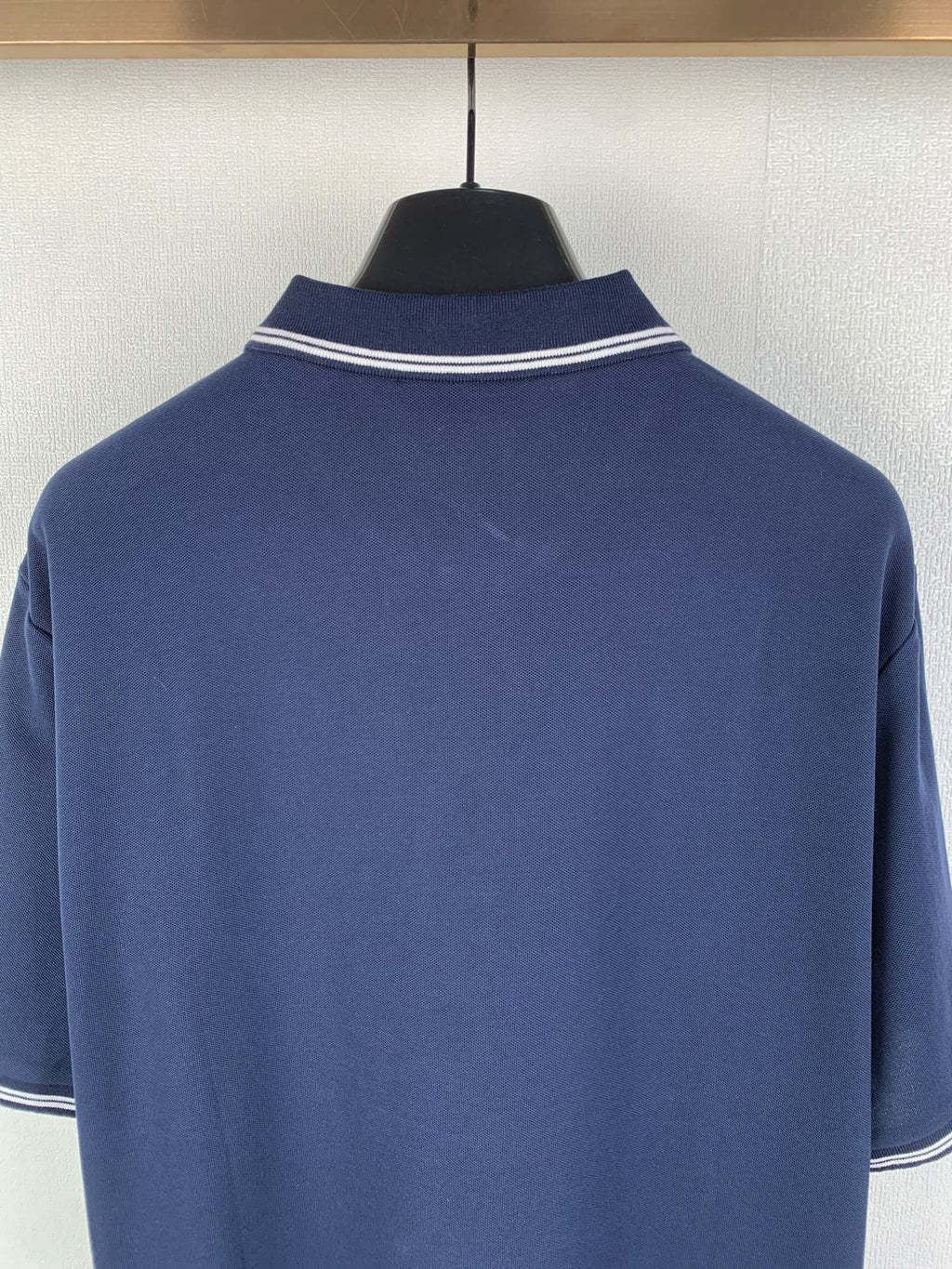 Navy polo shirt neckline with white double-stripe collar trim