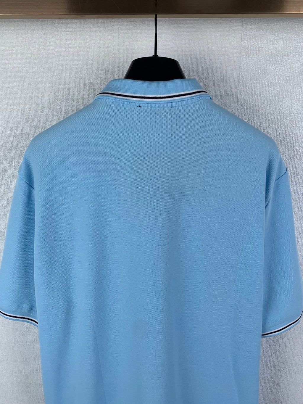 Light blue polo shirt back with white-trim collar and short sleeves