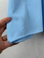 Light blue polo shirt hem and sleeve cuff area with textured fabric