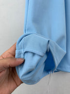 Light blue polo sleeve cuff detail with white-and-navy striped trim