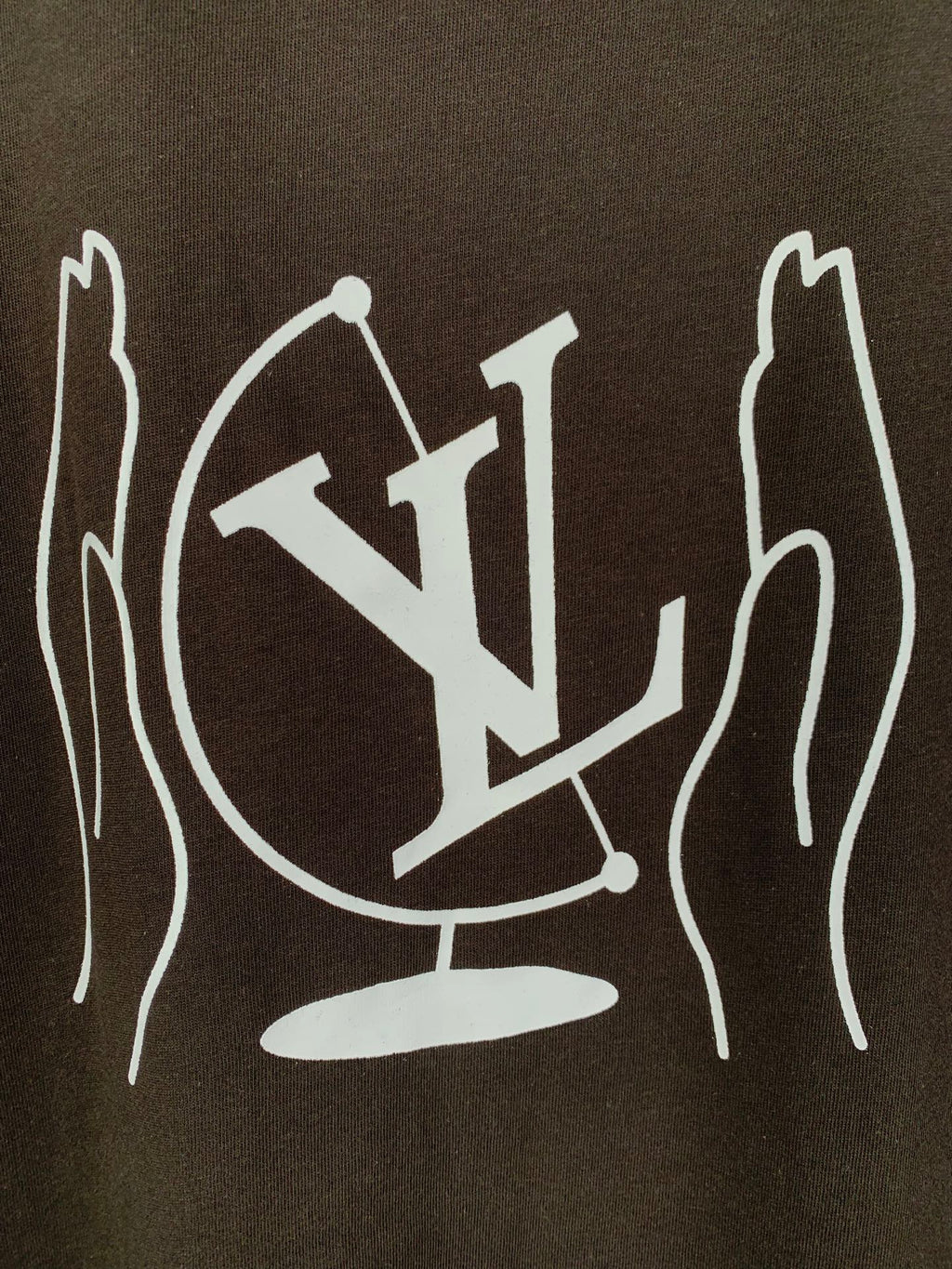 Close-up of white LV-style graphic print on dark brown T-shirt back