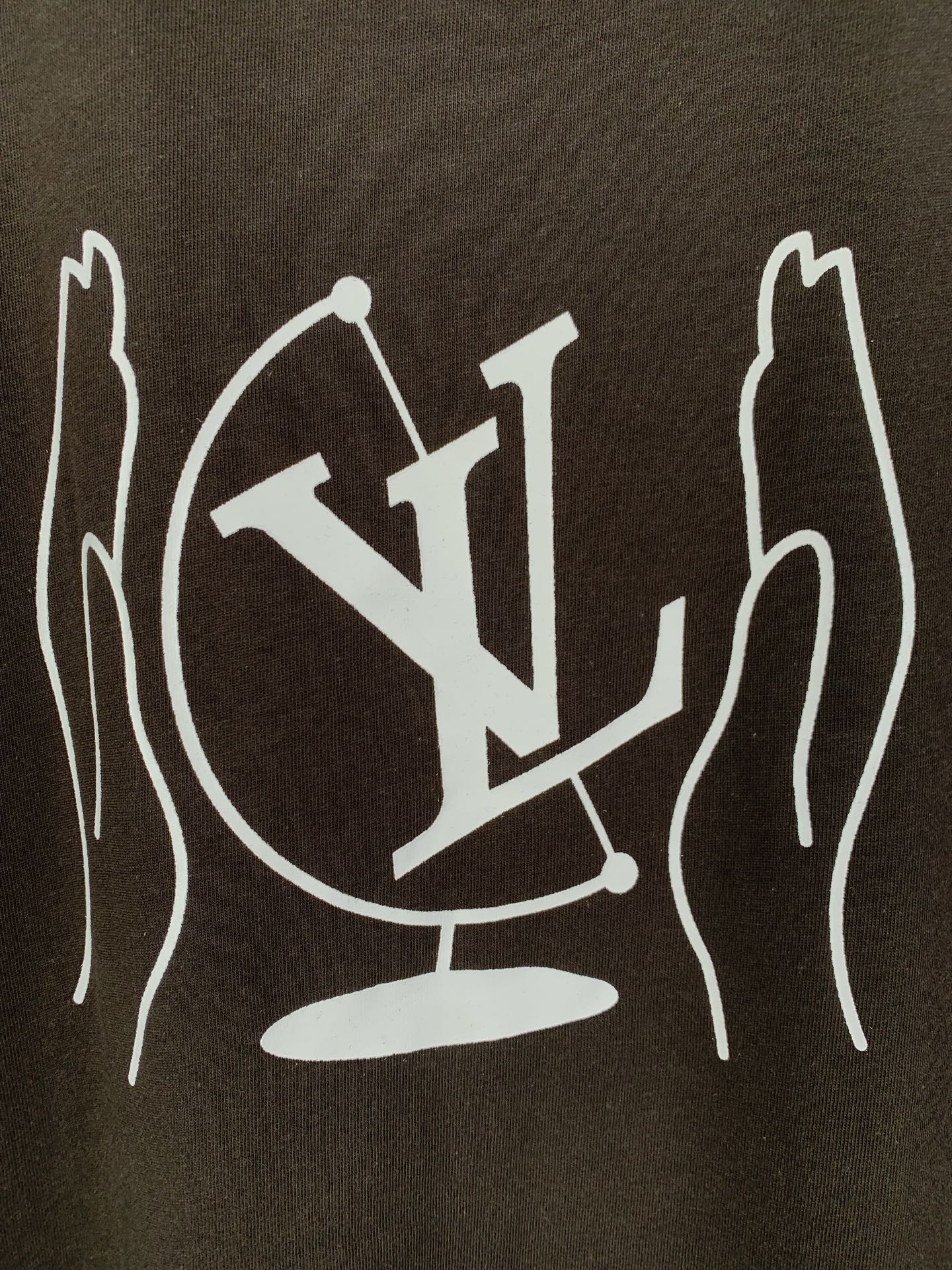 Close-up of white LV-style graphic print on dark brown T-shirt back