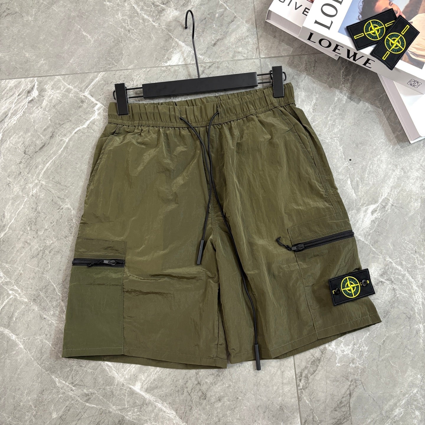 Olive cargo shorts with drawstring waist and side zipper pocket with Stone Island patch