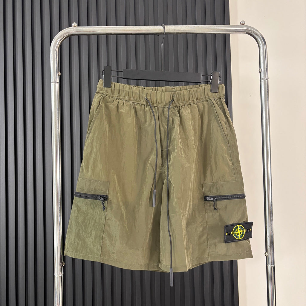 Olive cargo shorts with drawstring waist, flap side pockets, and Stone Island patch
