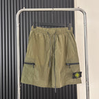 Olive cargo shorts with drawstring waist, flap side pockets, and Stone Island patch
