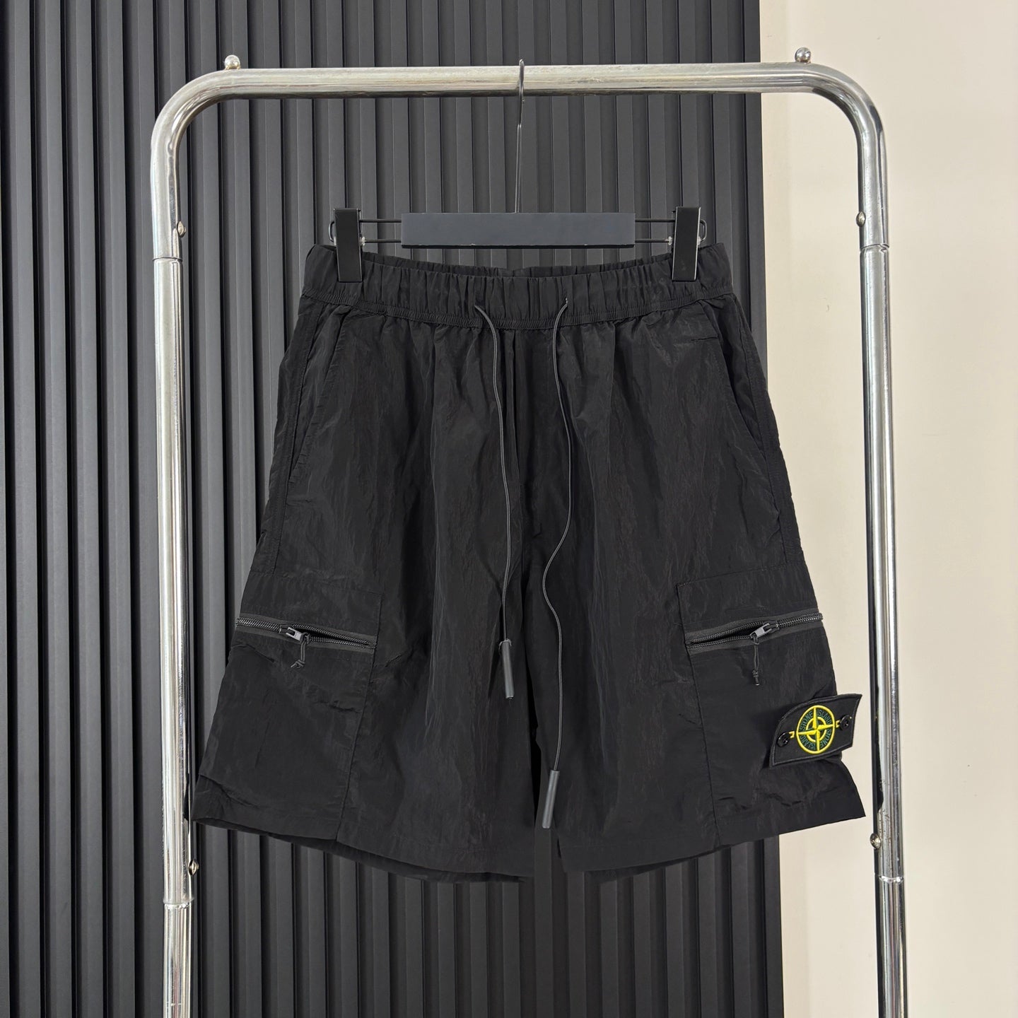 Black cargo shorts with drawstring waist, side pockets, and Stone Island patch
