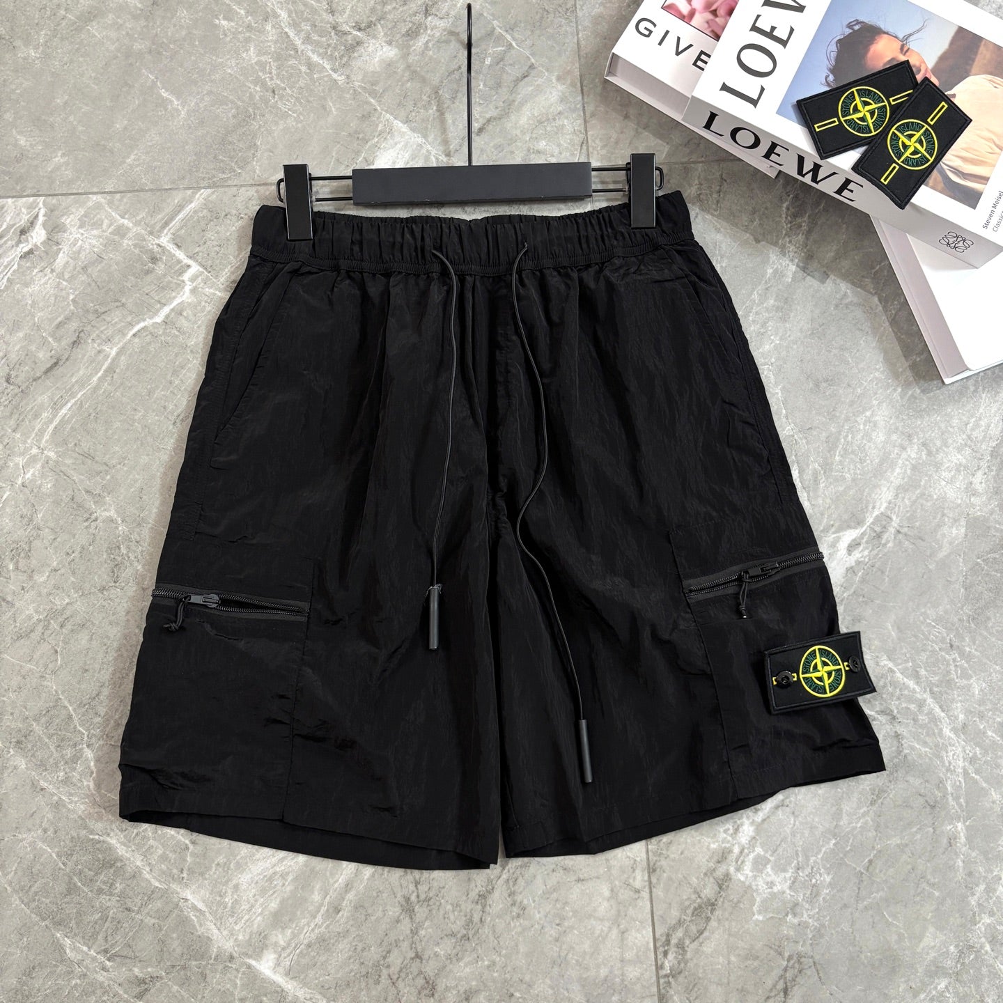 Black cargo shorts with drawstring waist and side zipper pocket with Stone Island patch