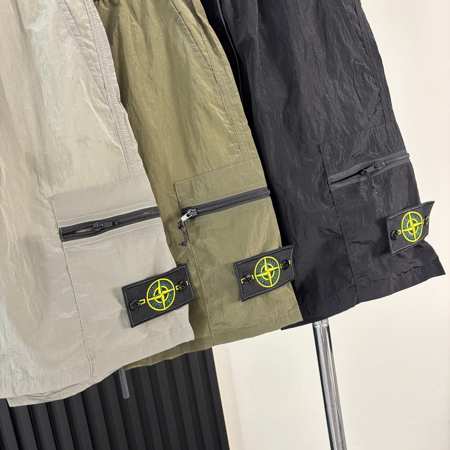 Cargo shorts side with zipper pocket and Stone Island patch in light and dark tones