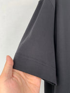 Dark short-sleeve T-shirt hem detail with visible stitching