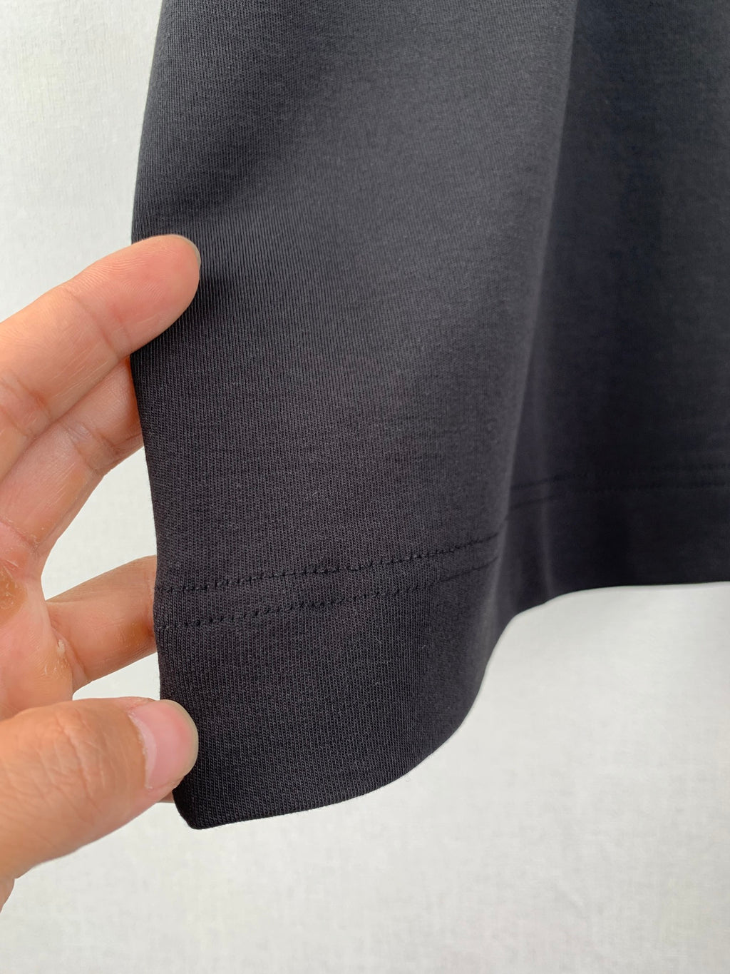 Dark T-shirt sleeve hem with stitched seam and cuff edge
