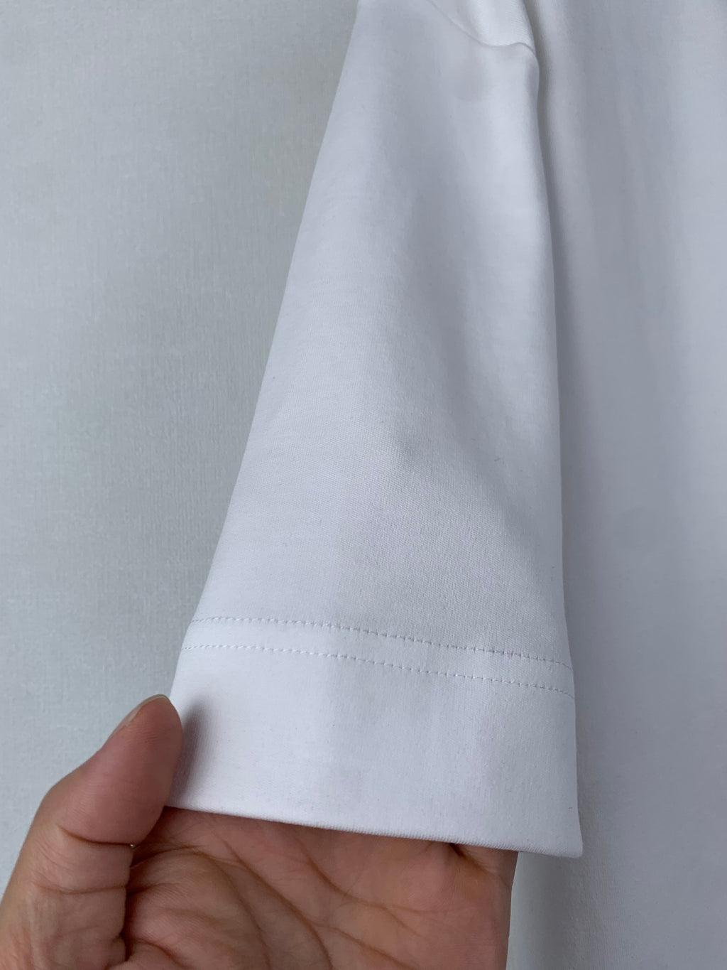 White Fendi T-shirt hem close-up with visible stitching