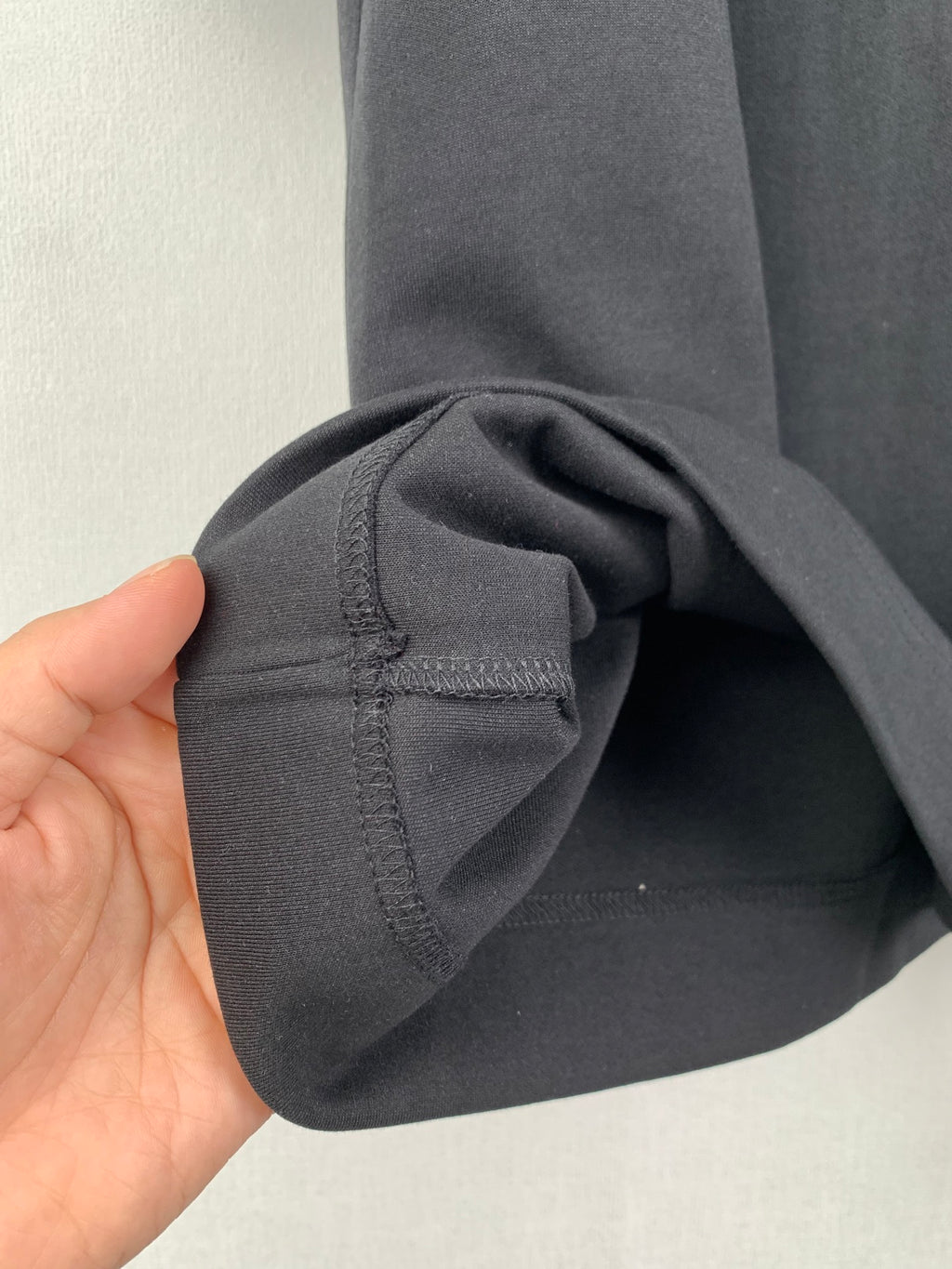 Black short-sleeve T-shirt sleeve with fabric fold and stitching