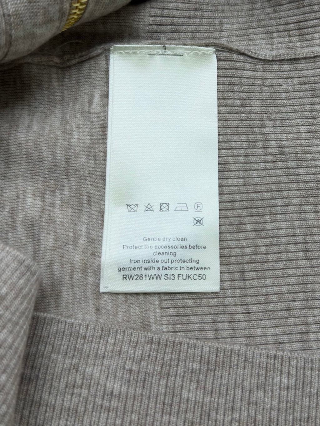 White fabric size label inside heather gray sweater with care icons