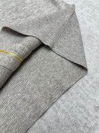 Ribbed cuff and sleeve end on heather gray sweater with gold zipper trim