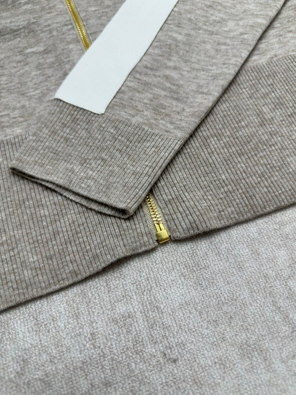 Heather gray zip-front sweater with gold zipper and ribbed cuffs in view