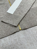 Heather gray zip-front sweater with gold zipper and ribbed cuffs in view