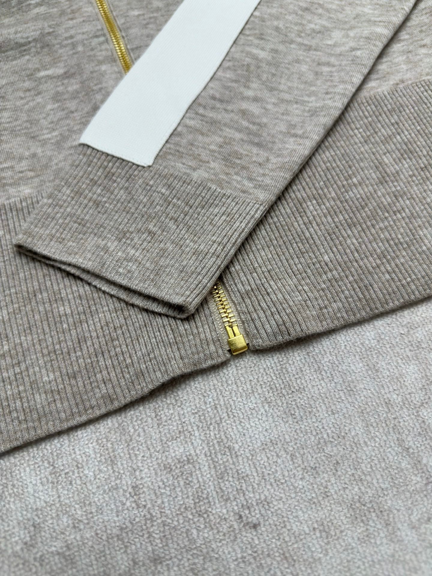 Heather gray zip-front sweater with gold zipper and ribbed cuffs in view
