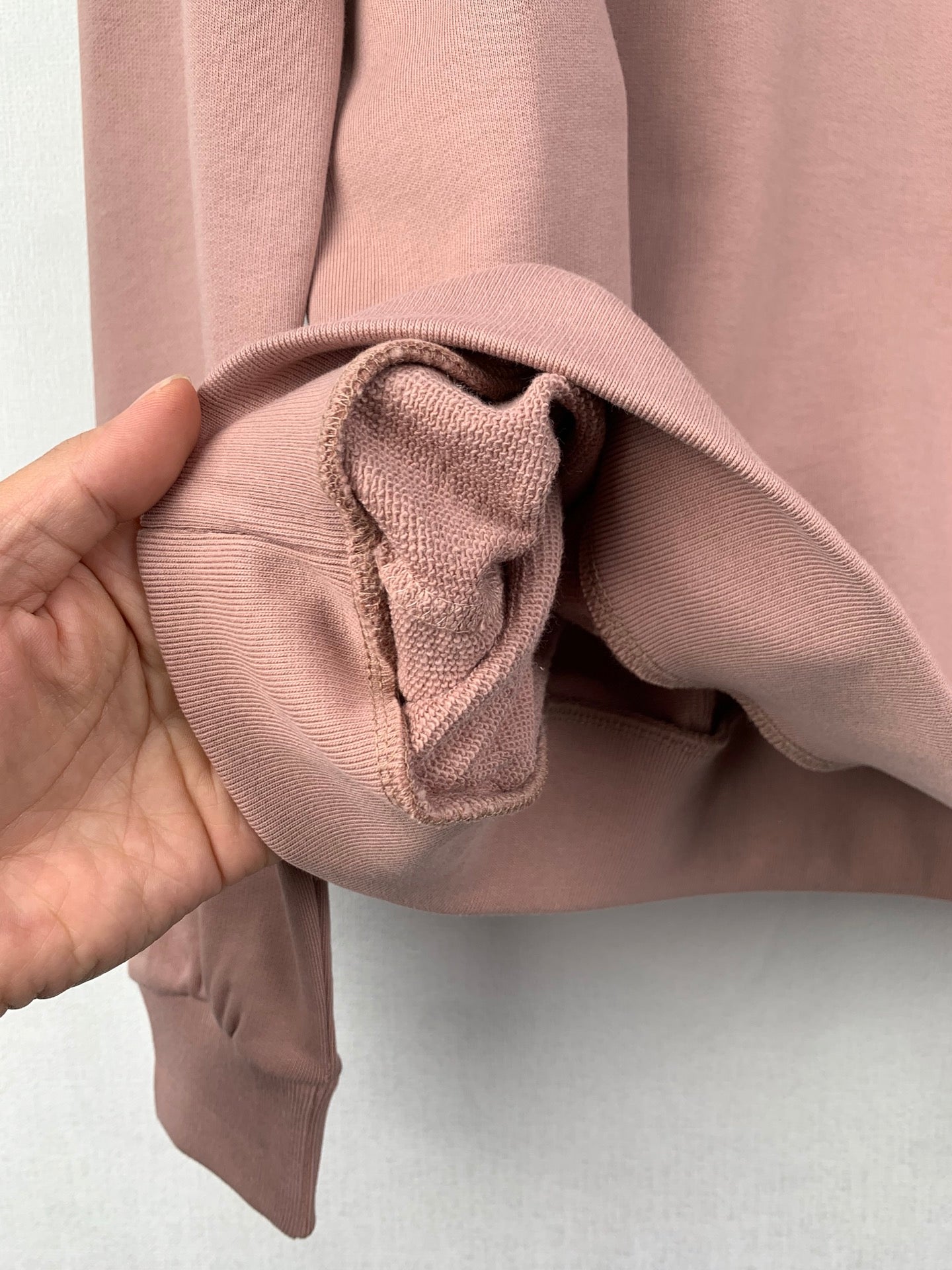 Mauve pink sweatshirt cuff opening with inner seam detail at long sleeve