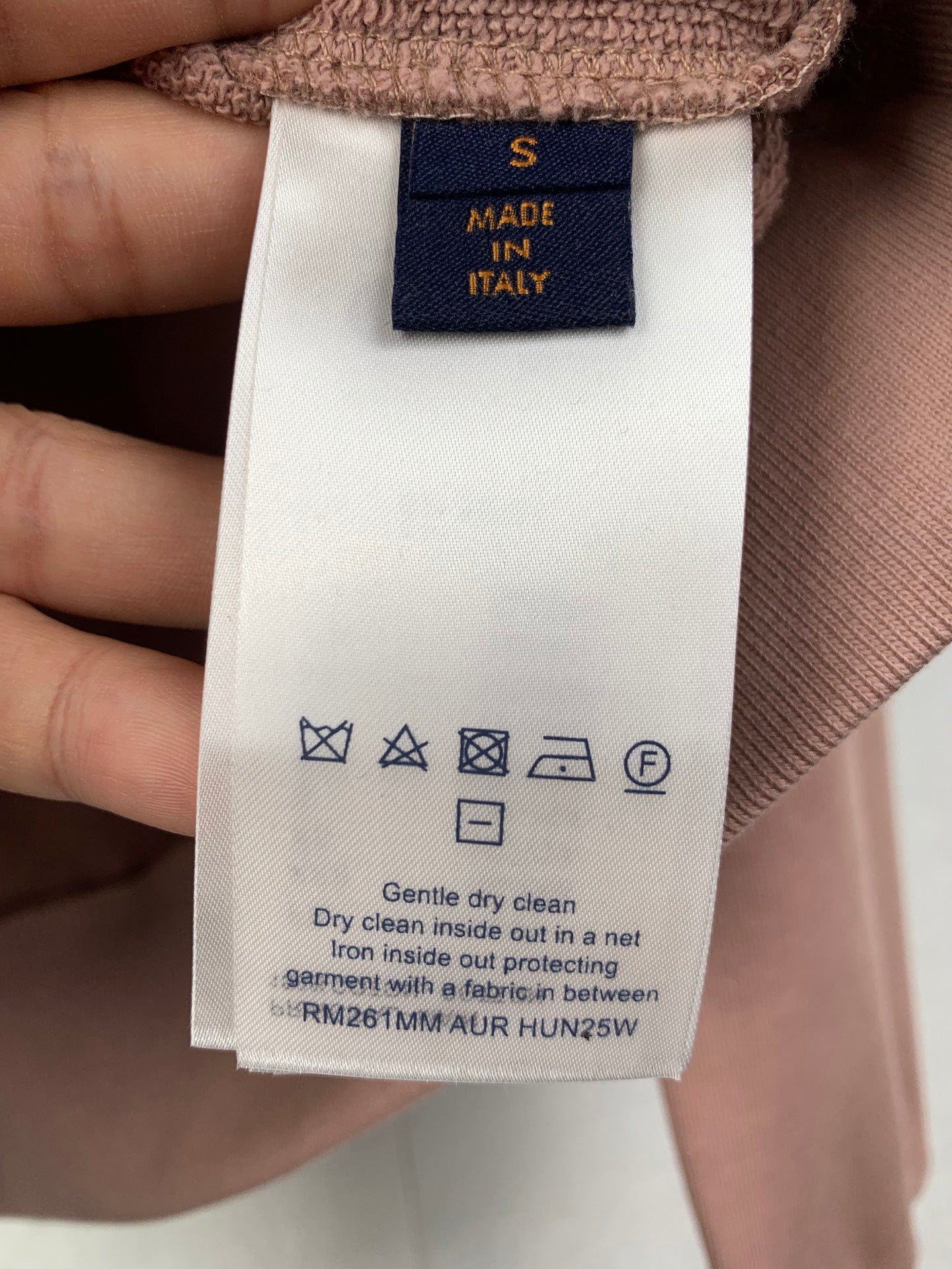 Garment care label on brown fabric long top neckline