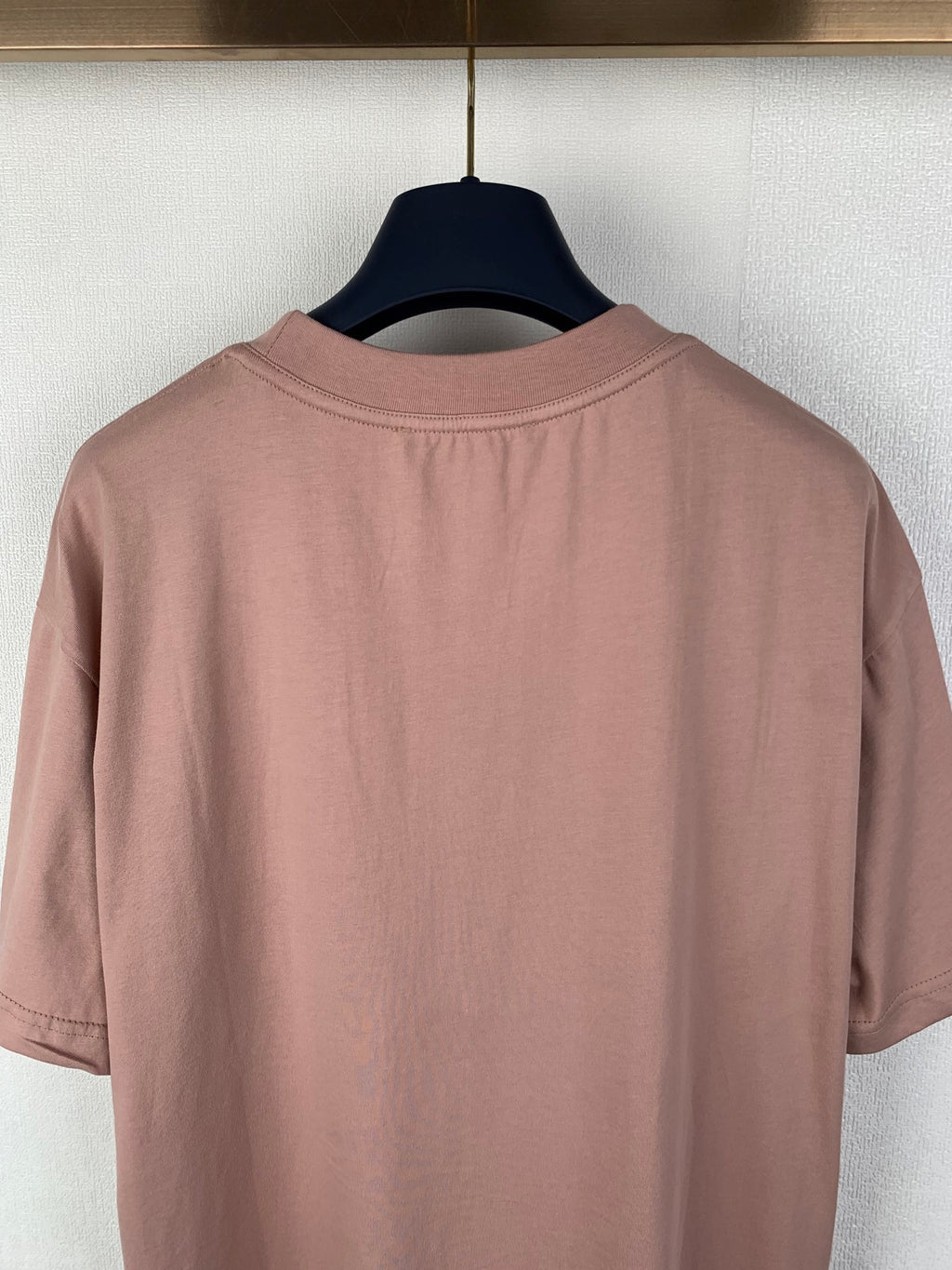 Dusty pink T-shirt back close-up with crew neck seam and short sleeves