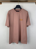 Dusty pink T-shirt with crew neck, short sleeves, and small logo patch