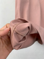 Dusty pink T-shirt sleeve cuff close-up with gathered stitching