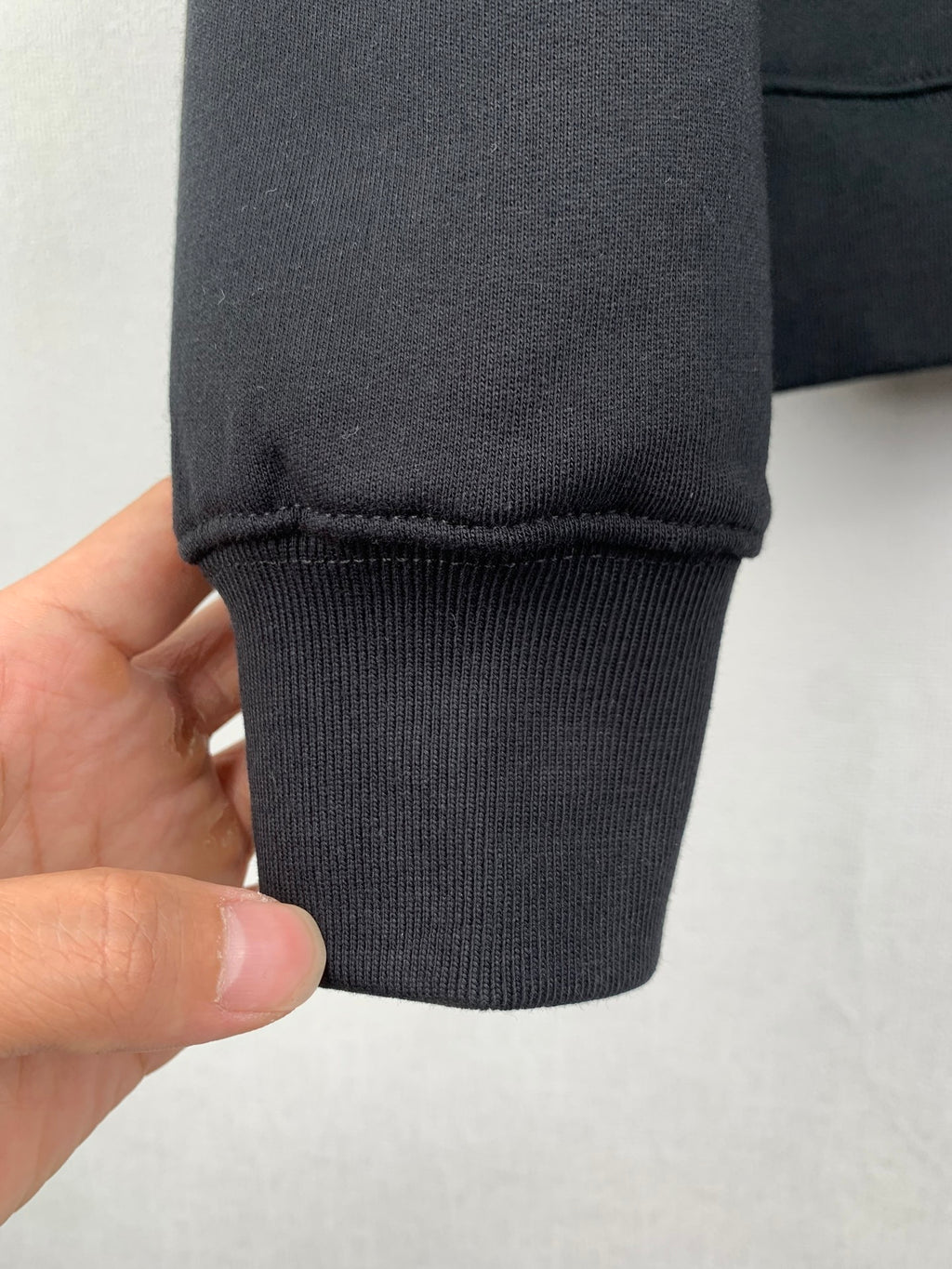Black sweatshirt sleeve cuff with ribbed hem and stitching