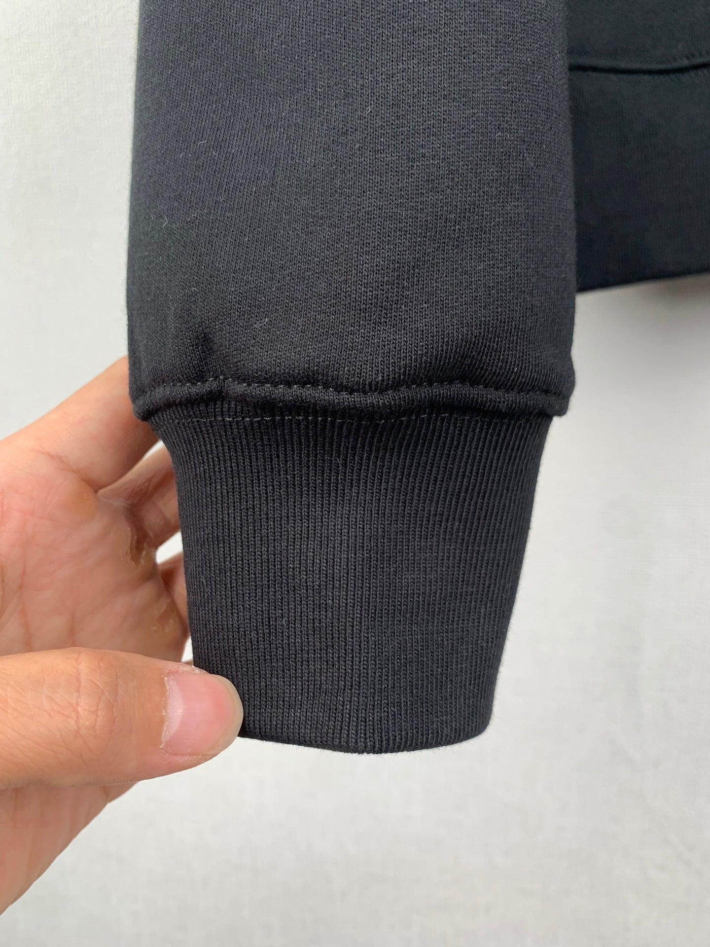 Black sweatshirt sleeve cuff with ribbed hem and stitching