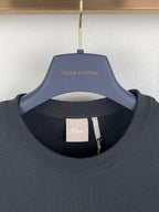 Black crewneck sweatshirt with Dior neck label and Louis Vuitton hanger