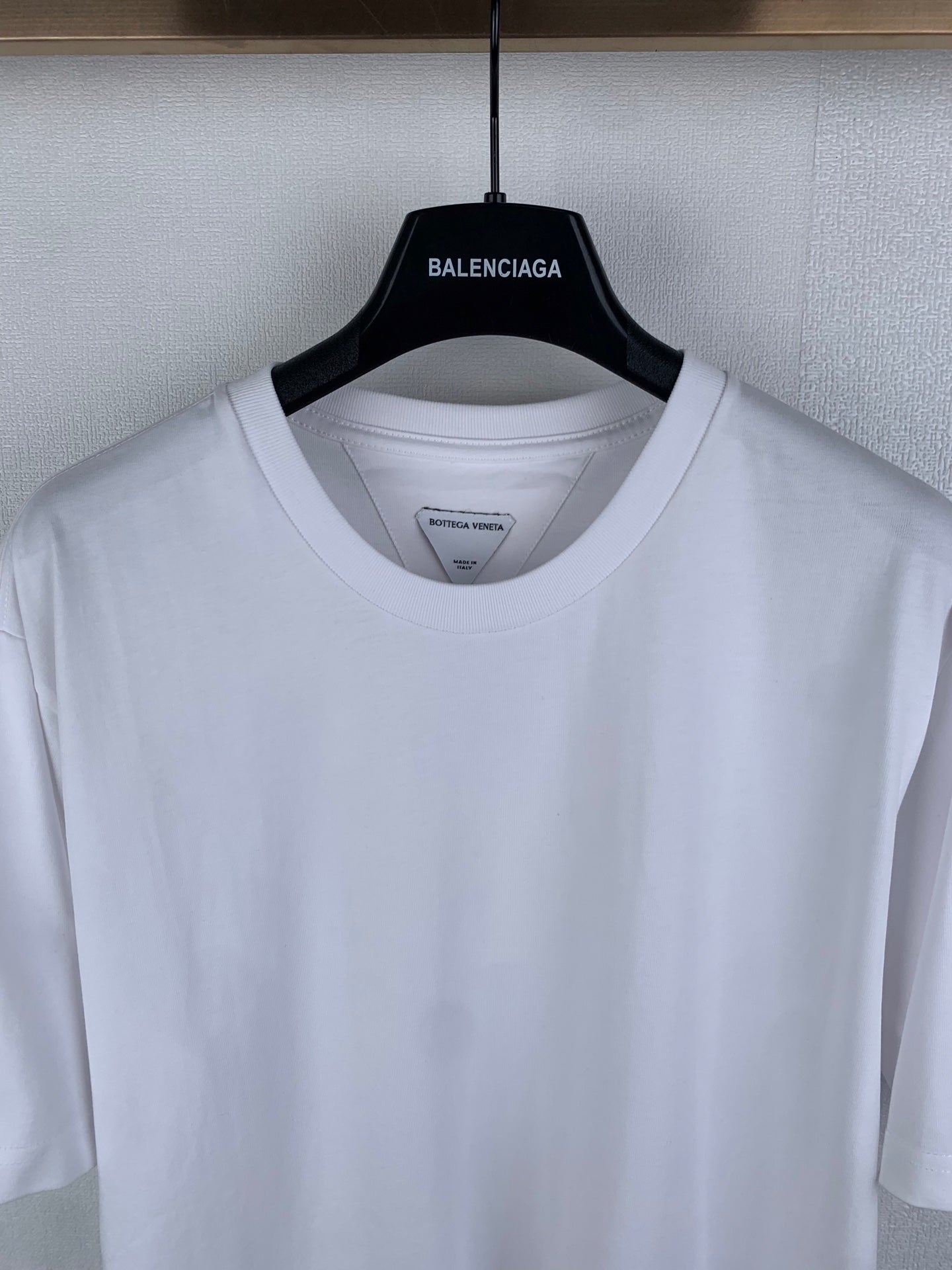Off white crew-neck T-shirt, neckline and shoulder seam close-up
