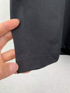 Close-up of dark charcoal T-shirt hem stitching and fabric texture