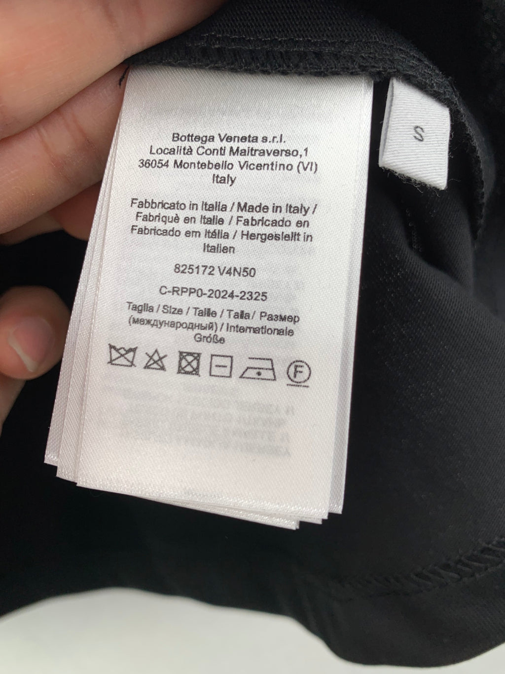 Interior neck label with size and care information on dark crewneck T-shirt
