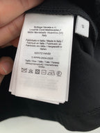 Interior neck label with size and care information on dark crewneck T-shirt